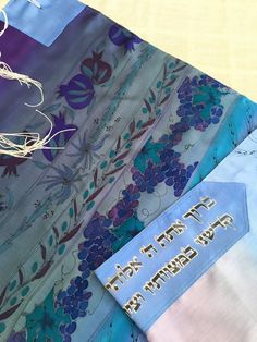 "A silk prayer shawl with matching bag for woman. This one of a kind Jewish woman's prayer shawl (also called tallit in Hebrew) is made of silk crepe satin 12.5mm. A painting of the Seven Species on a blue or lilac silk prayer shawl wraps you with the divine spirit and holiness. Buy this tallit for the girl who celebrates her Bat Mitzvah. Dimensions: 22\"/71\" (55 /180 cm) Materials: Silk crepe satin 12.5mm. Silk colors. Care: Hand wash, iron on the rear side. Can be ordered with the following t Baruch Atah Adonai, Divine Spirit, Jewish Prayer, Silk Colors, Jewish Women, Hand Painted Gifts, Prayer Shawl, Pad Bag, Jewish Gifts