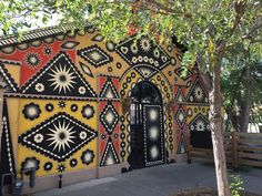 an artisticly designed building is painted with black, yellow and red colors