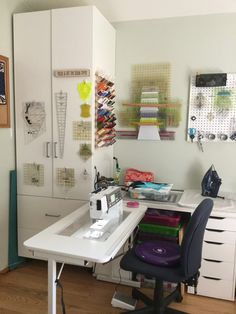 a sewing machine sitting on top of a table next to a white desk with lots of crafting supplies