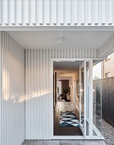 an open door leading into a room with white walls and flooring on the outside