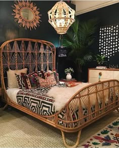 a rattan bed with pillows and blankets on it in a room decorated with plants