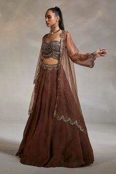 Cognac brown organza scallop embellished over-sized cape with sheer sleeves. Paired with lehenga with attached cancan and padded corset blouse.
Component: 3
Pattern: Embroidery
Type Of Work: Beads
Neckline: Corset: Sweetheart; Cape: Open
Sleeve Type: Corset: Sleeveless; Cape: Sheer
Fabric: Corset: Velvet; Cape: Organza; Lehenga: Satin Organza
Color: Brown
Other Details: 
Boned corset blouse
Embroidered waistband
Attached lining
Approx weight (in kg) : 1.7
Note: The neckpiece worn by the model is Cape Organza, Cape Lehenga, Cape Set, Blouse Yoke, Brown Corset, Velvet Bustier, Organza Lehenga, Velvet Cape, Corset Blouse