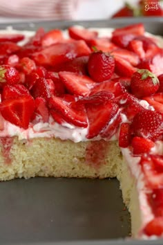 a cake with white frosting and strawberries on top is sitting on a pan