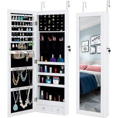 an open mirrored closet with jewelry hanging on the door and mirror in front of it