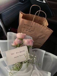 there is a bouquet of flowers in the back seat of a car with a note attached to it