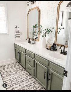 a bathroom with black and white tiles on the floor, two sinks and a large mirror