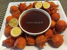 a white plate topped with fried food and dipping sauce