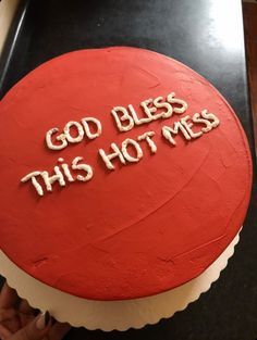 a red cake with white frosting that says god bless this hot mess