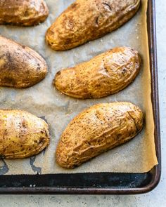 baked potatoes on a baking sheet ready to go into the oven for roasting in the oven