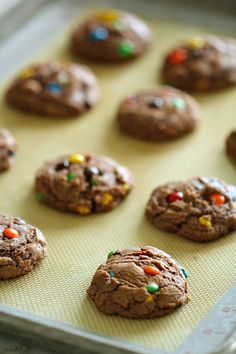 chocolate cookies with sprinkles are on a baking sheet and ready to be baked