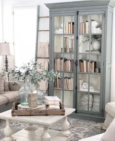 a living room filled with furniture and bookshelves on top of a carpeted floor