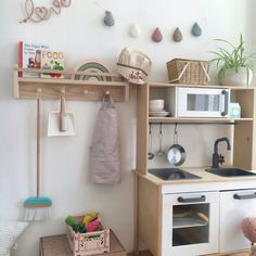 a small kitchen with wooden shelves and white appliances