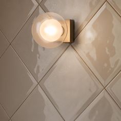 a light that is on the side of a wall in a room with white tiles