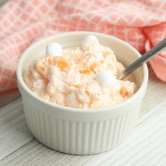 a white bowl filled with food and marshmallows on top of a table