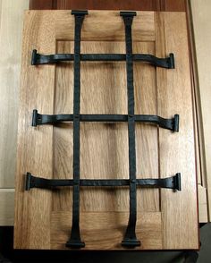 a close up of a wooden door with black iron bars on the front and sides