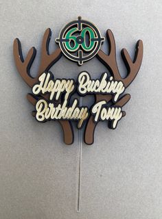 a cake topper with the words happy birthday tony and deer antlers on it