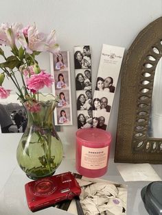 a vase filled with pink flowers sitting on top of a table next to a mirror