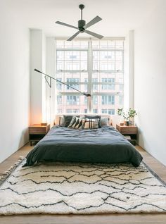 a bedroom with a large bed and a ceiling fan in it's center area