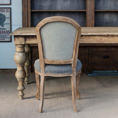 a chair sitting in front of a wooden desk and bookshelf next to a bookcase