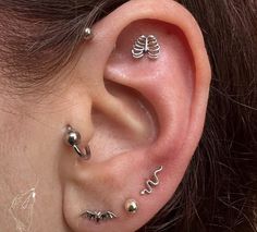 a woman's ear with three piercings on it