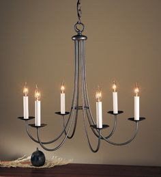 a chandelier with six lit candles hanging from it