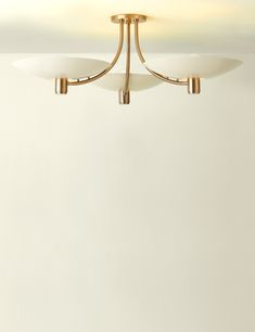 two lights are hanging from the ceiling in a room with white walls and flooring