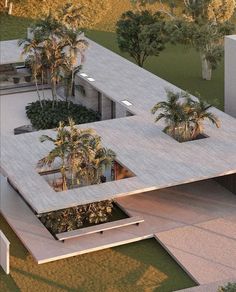 an aerial view of a modern house surrounded by palm trees