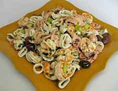 pasta salad with shrimp and olives on a yellow plate