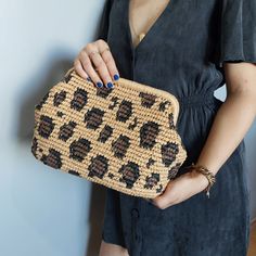 a woman holding a woven purse in her hands