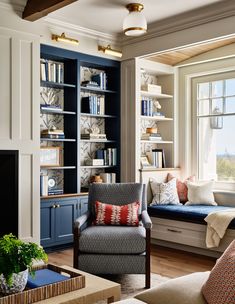 a living room filled with lots of furniture and bookshelves next to a window