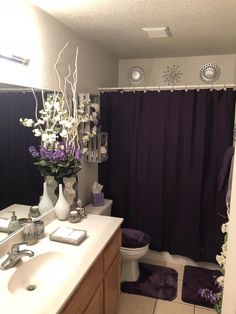 the bathroom is decorated in purple and white