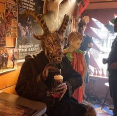 a group of mannequins dressed in costumes and holding drinks at a bar