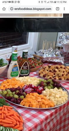 a table topped with lots of different types of food on top of a red and white checkered table cloth