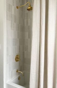 a white bath tub sitting next to a shower with a curtain on it's side