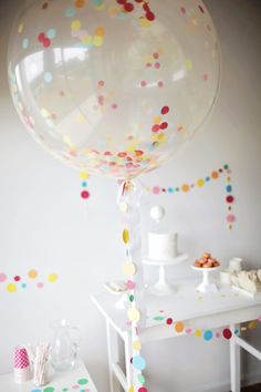 a large balloon with confetti on it is in the middle of a room