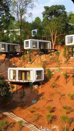 several tiny houses on top of a hill with trees in the backgrouds