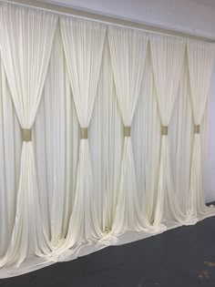 a room with white drapes hanging on the wall