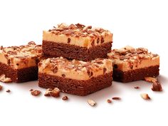 four pieces of chocolate cake with nuts on top