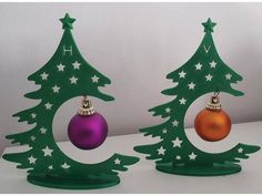 two green christmas trees with ornaments on them