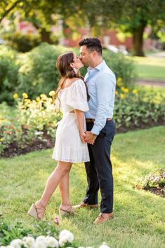 an engaged couple kissing in the park