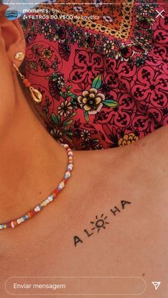 a woman with a tattoo on her chest and the words aloha written in spanish