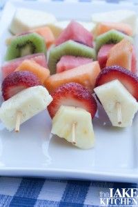 fruit skewers are arranged on a white plate