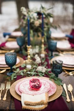 the table is set with plates, silverware and red napkins for an elegant dinner