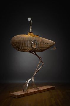 a wooden object with metal legs and a light on it's head in the shape of a ship