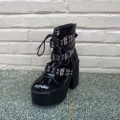 The Yru Smash Strapped Platform Boot In Black Is A 3" Platform With A 5" Heel, Adjustable Front Lacing, Adjustable Front Straps With Grommet Hardware And Back Zip Closures. #Yru #Yrusmashstrapped #Yrusmashblack Edgy Black Closed Toe Platform Boots, Black Heels For Streetwear, Black Chunky Platform Heels In Alternative Style, Rock Style Black Platform Boots With Round Toe, Black Chunky Platform Heels Alternative Style, Black Closed Toe Alternative Heels, Gothic Heels With Round Toe For Night Out, Gothic Round Toe Heels For Night Out, Alternative Style Black Closed Toe Heels