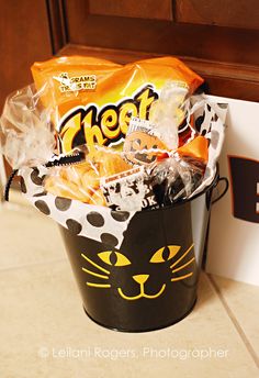 a black bucket filled with candy sitting on top of a counter