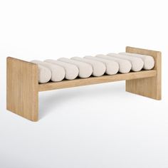 a wooden bench with six white pillows on the bottom and backrests, all stacked together