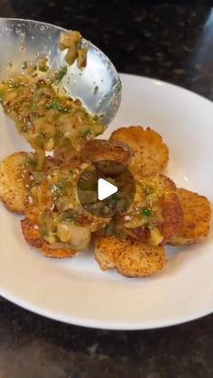 a white plate topped with fried food and a spoon