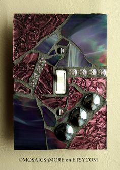 a decorative light switch plate cover in purple and silver