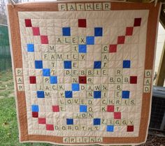 a quilt hanging on the side of a building with words written in it that spell out father